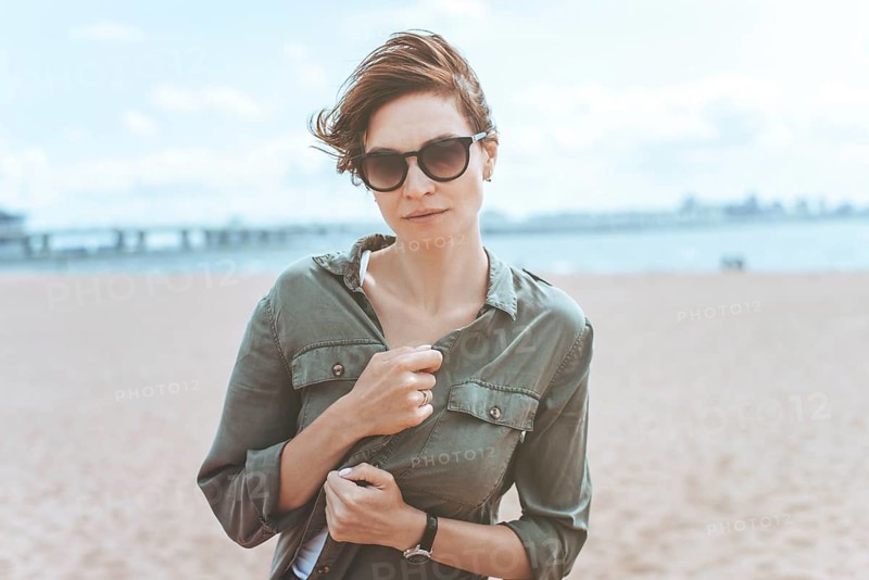 Image of a beautiful woman on the beach of the Gulf of Finland in St. Petersburg. Windy weather. Happiness