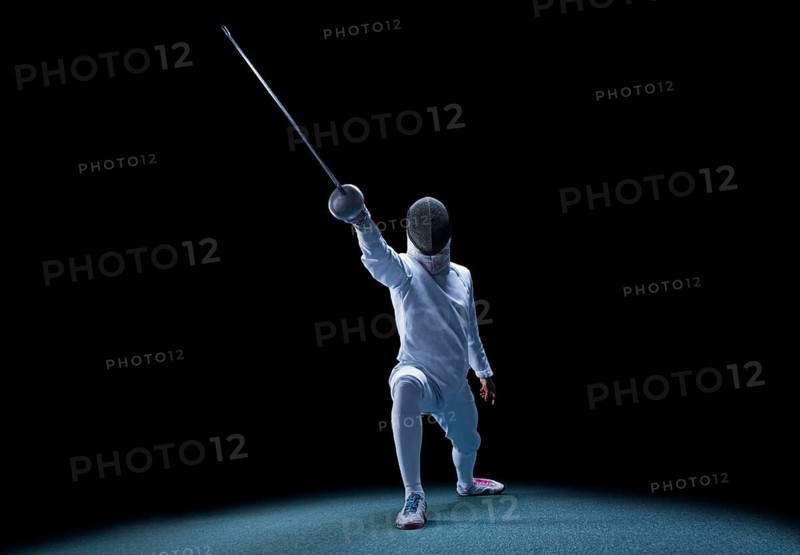 The fencer moves forward with a sword in his hand. Sport concept.