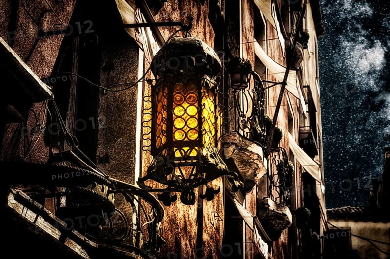 Old-fashioned lantern on the wall of a house. Mystical concept.