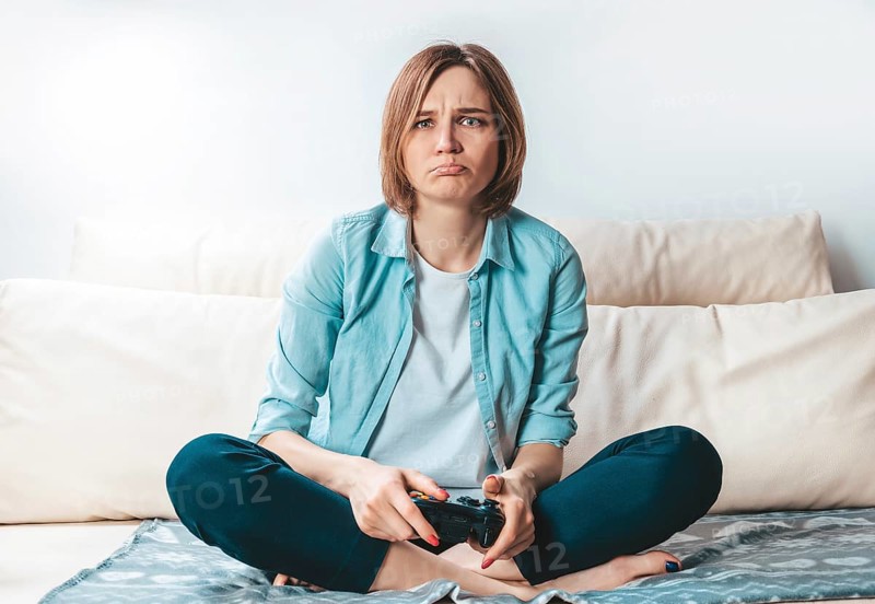 Girl with a joystick in her hands cries because of a defeat in the game. ESports concept.