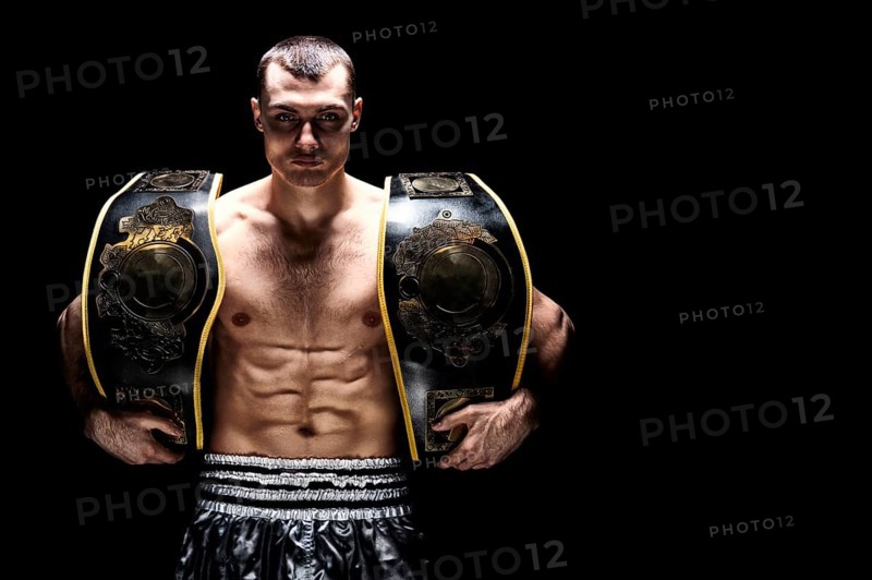 Kickboxing world middleweight champion stands with two belts. The concept of a healthy lifestyle