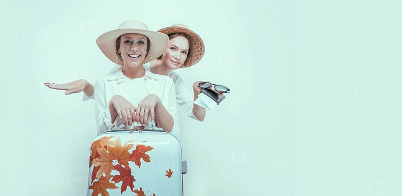 Portrait of two smiling women with passports