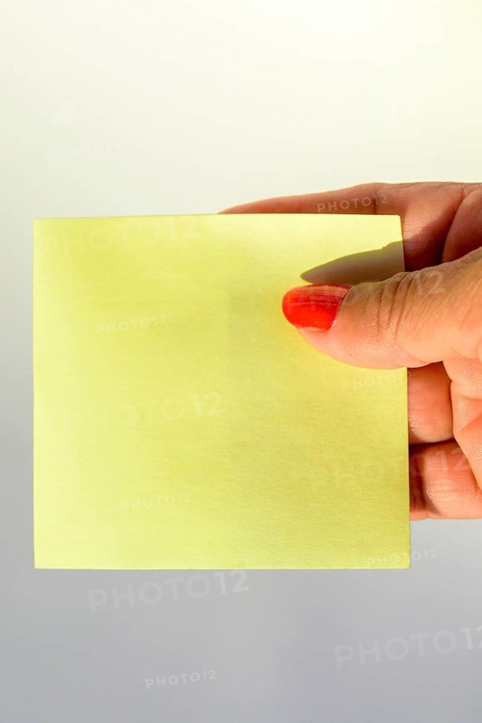 Woman's hand with painted nails holding blank letter paper on pure white background
