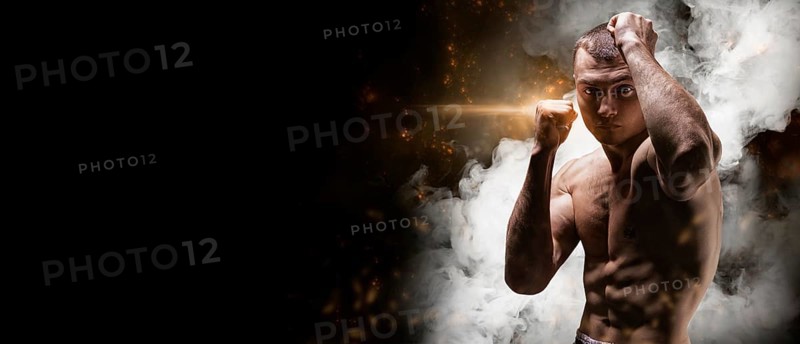Professional boxer posing in the studio. He stands in front of the camera and elbows. The concept of sport