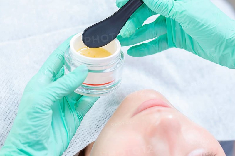 Image of a jar with a yellow mask for skin care. Concept for beauty salons.