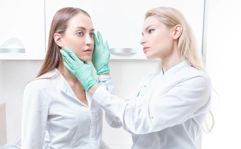 Beautiful girl at a consultation in the salon with a plastic surgeon. Beauty industry concept.
