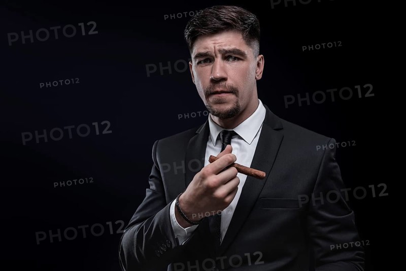 Portrait of a stylish man in a suit with a cigar. Business concept.