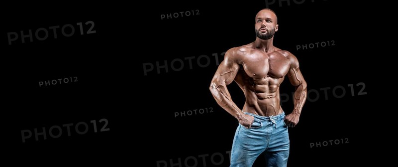 Isolated muscular man on a black background. Bodybuilding and fitness concept. Panorama.