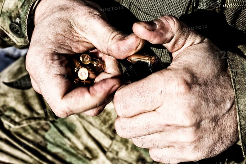 The fighter prepares a clip with bullets before the next fight.