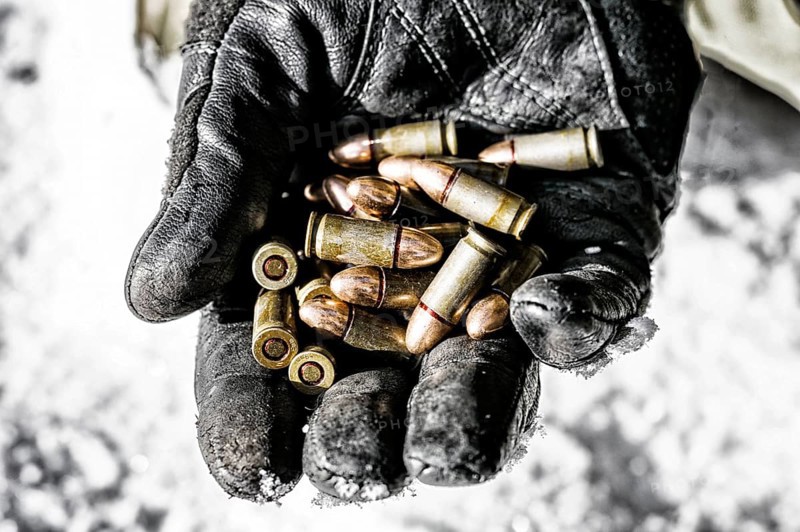 The fighter holds a handful of bullets in his palm for weapons.