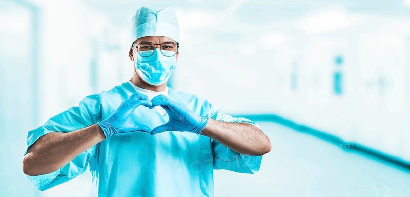 Portrait of a doctor in a hospital. He folded his hands in the shape of a heart. Medicine concept.