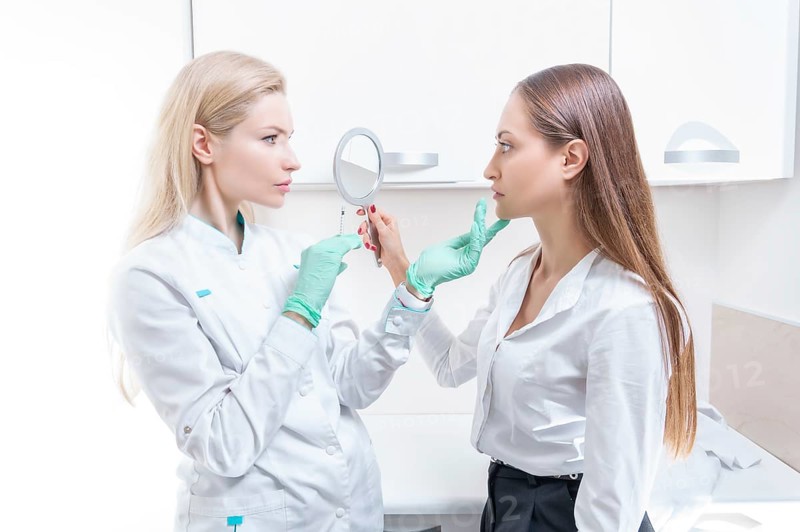 Portrait of the beautician and patient. The doctor injects botox. Skin rejuvenation and lifting concept.