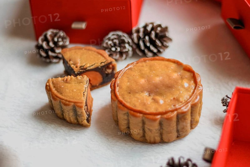 A single mooncake piece placed prominently with a festive backdrop