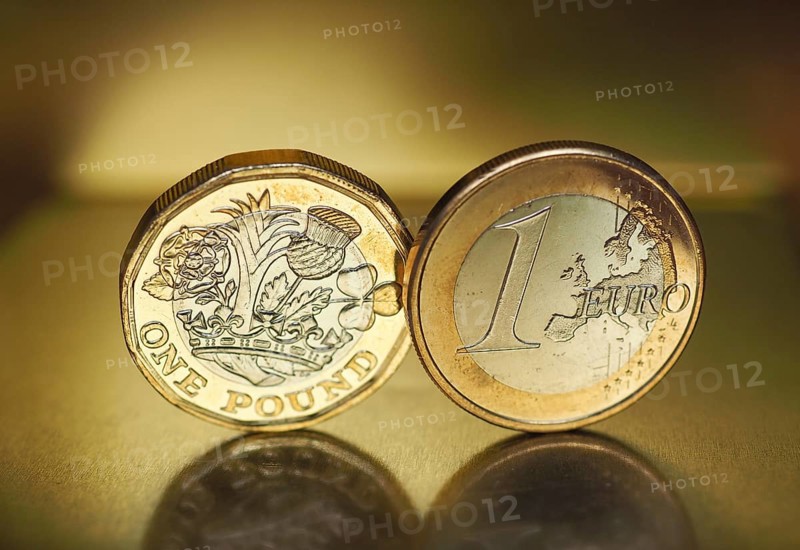 1 pound and 1 euro coin over metal background