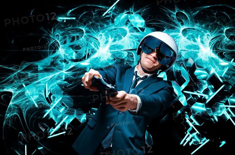 Portrait of a man in a suit and helmet of a pilot with a joystick in his hands. He enthusiastically plays a computer game. Game space. Game concept.