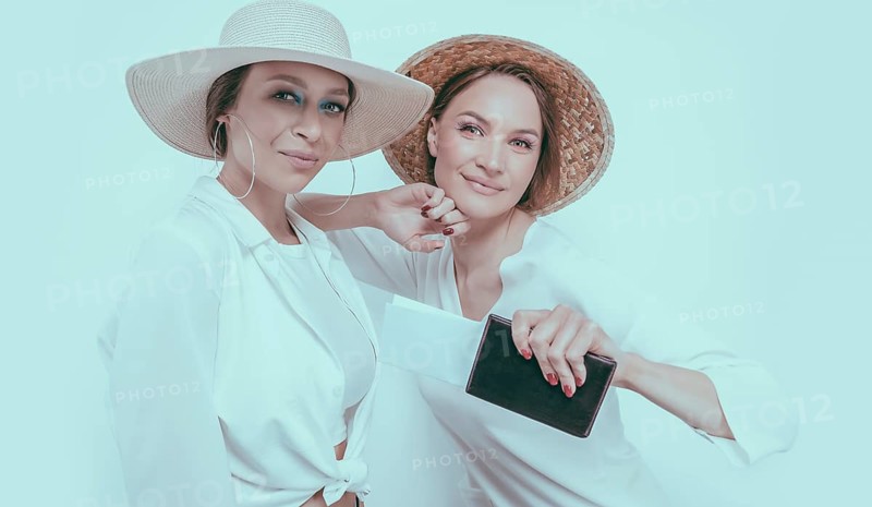 Portrait of two smiling women with passports and boarding passes in their hands. Travel concept.