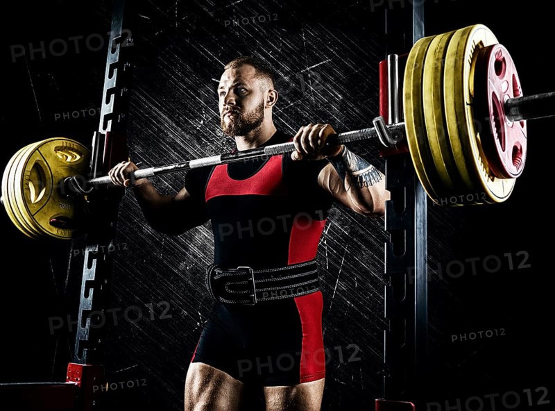 Professional athlete prepares to squat with a barbell.