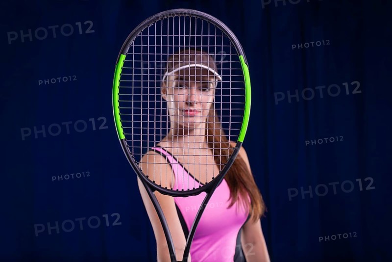 Portrait of a beautiful tennis player in a pink dress on the court. Sports concept.