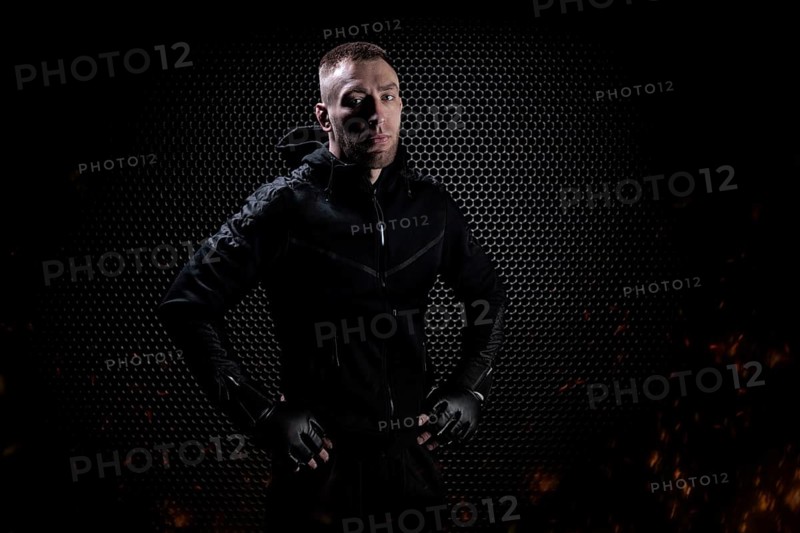 Mixed Martial Arts fighter posing on a metal grid background. Concept of mma