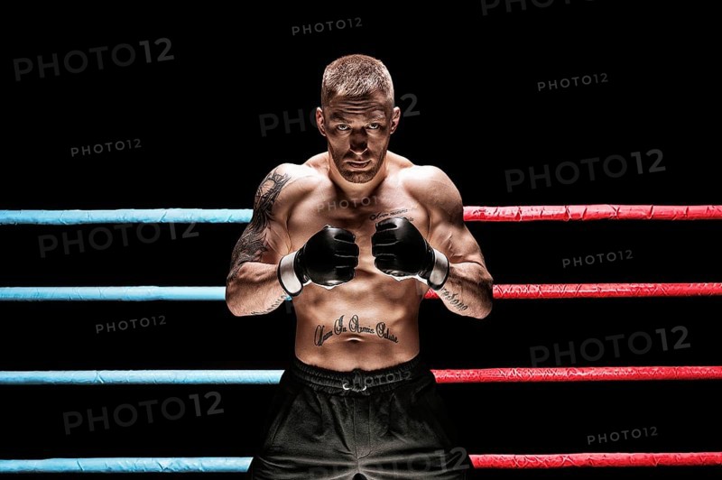 Mixed martial artist posing in boxing ring. Concept of mma