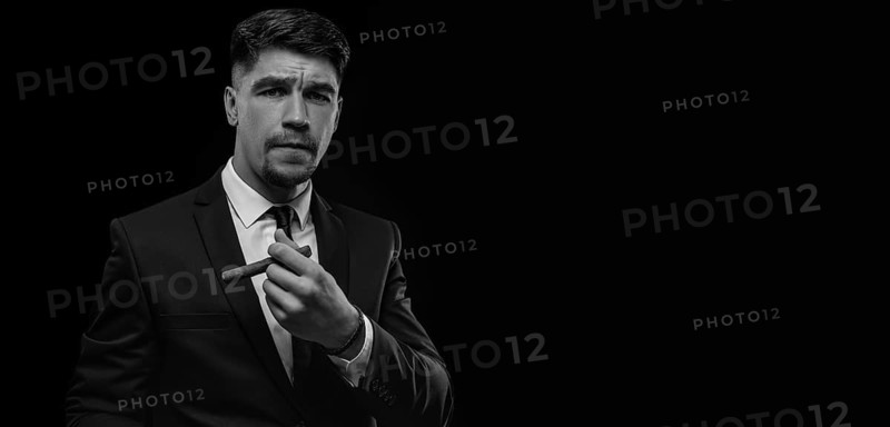 Portrait of a stylish man in a suit with a cigar. Business concept.