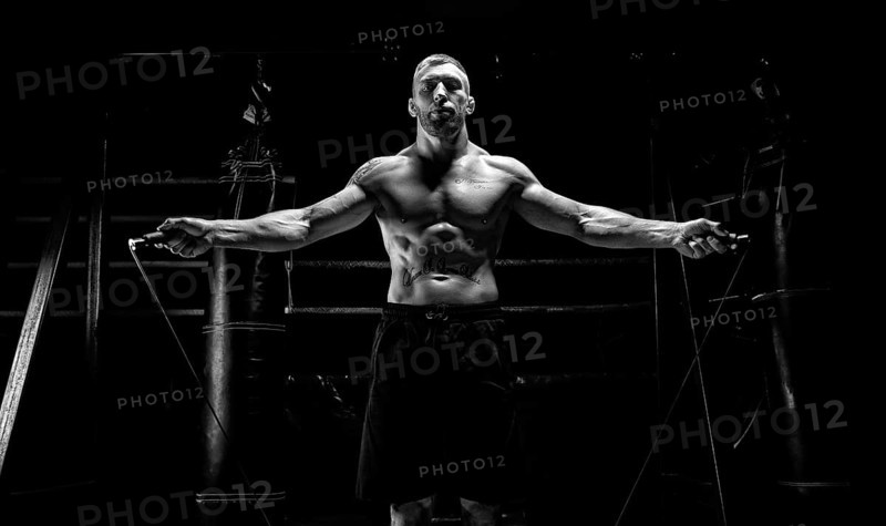 The athlete jumps on a skipping rope in the gym opposite the boxing ring. The concept of sport