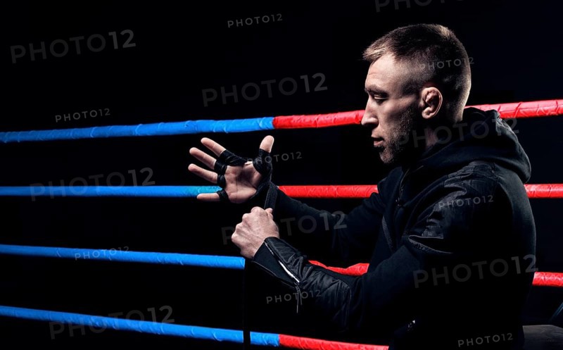 Mixed martial artist wraps bandages around his fist. Concept of mma