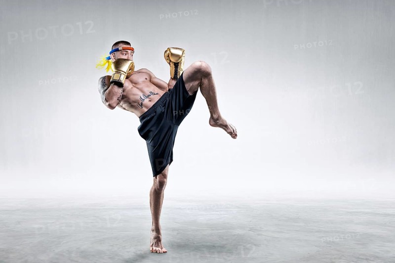 Portrait of a Thai boxer. He hits with his knee. Competitions and tournaments concept.