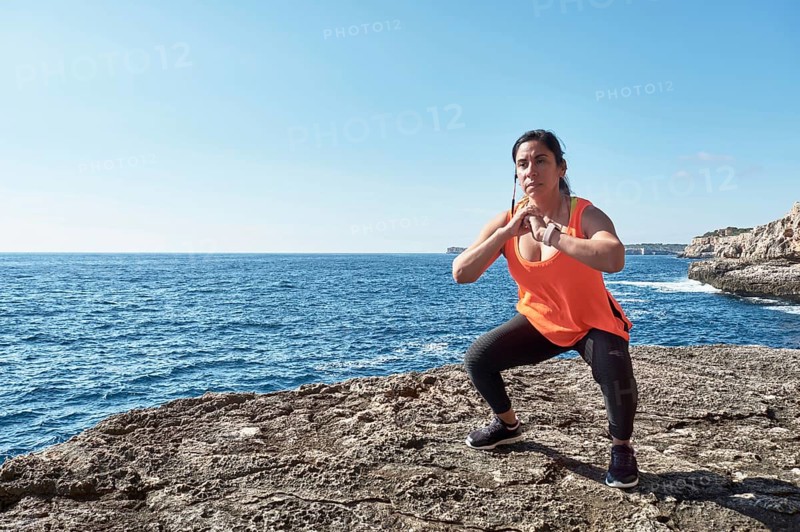 FITNESS WOMAN IN SPORTS SET TRAINING WITH ELASTIC BAND