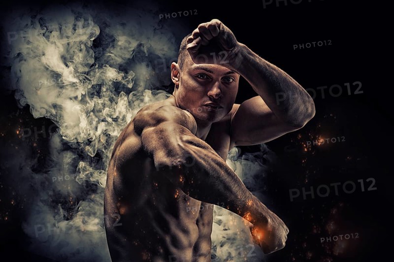 Professional boxer posing in the studio. He stands in front of the camera and elbows. The concept of sport