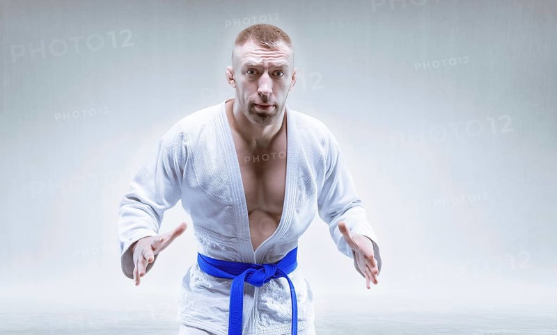 Sportsman in a kimono with a blue belt. The concept of karate and judo competitions.