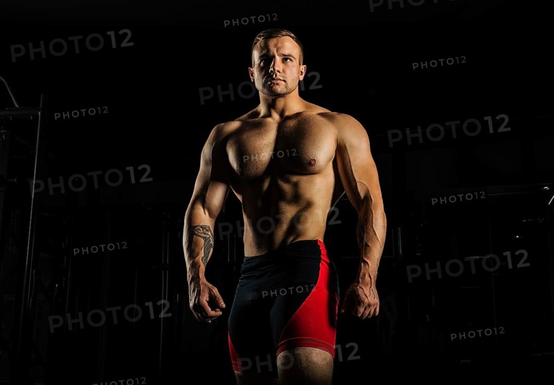 Portrait of a weightlifter who poses without a shirt. Front view
