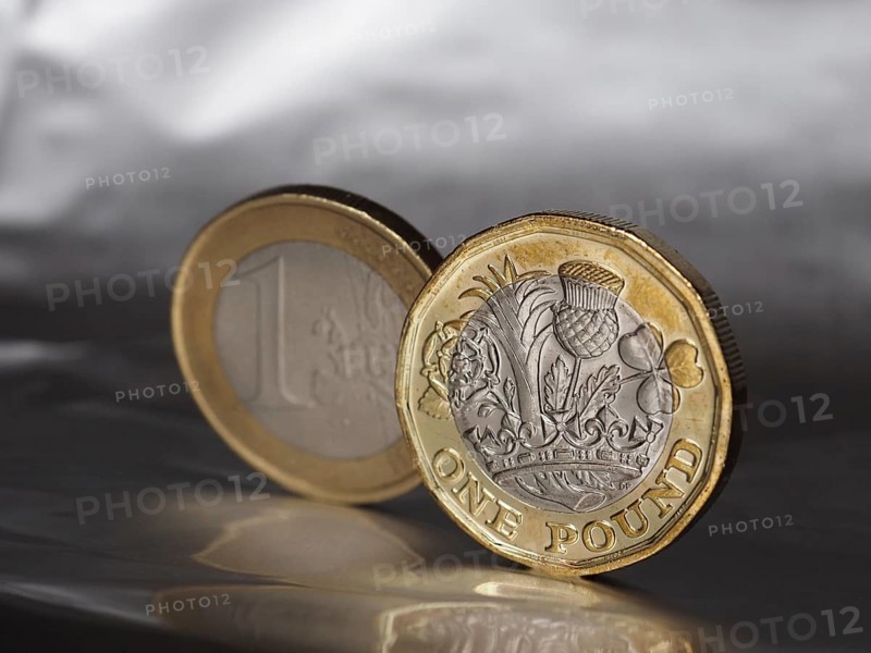 1 pound and 1 euro coin over metal background
