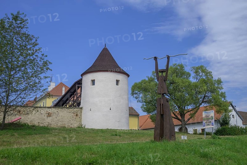 Tower of the fortified village and wooden sculpture