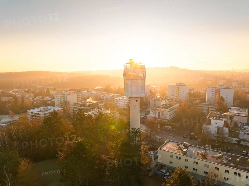 Aerial view morning mood with the sunlight illuminating a water tower and the city
