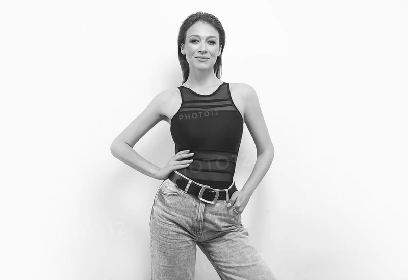 Portrait of a girl in a bodysuit and jeans. Women's underwear concept.