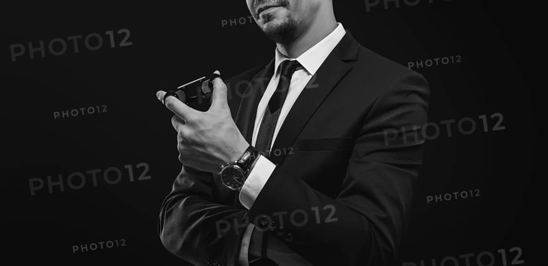 Image of an adult stylish man in a suit with a cigar. Cigar clubs concept.