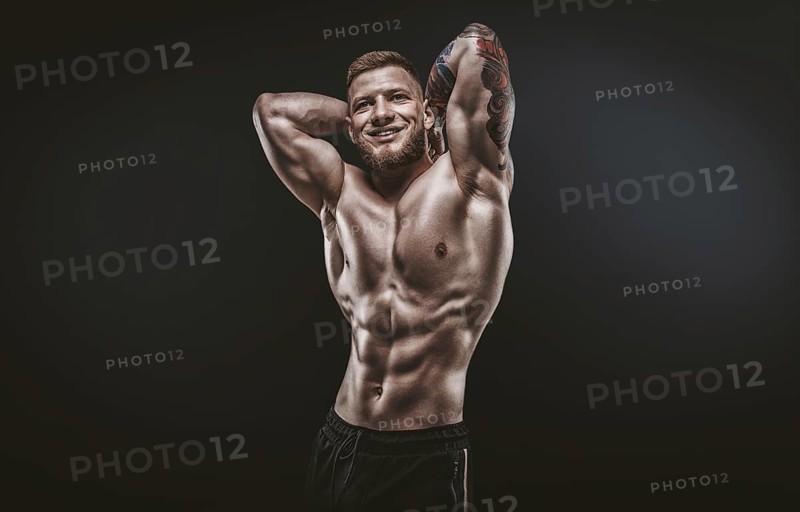 Young muscular guy posing in the studio. Fitness and nutrition concept.