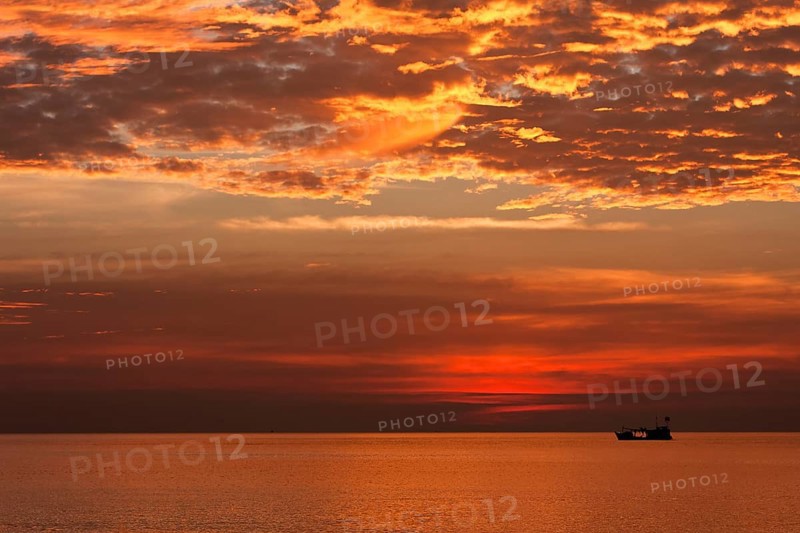 Red sunset and fishing boat