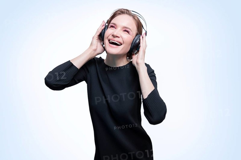 Portrait of a woman in professional headphones. White background. Dj concept.