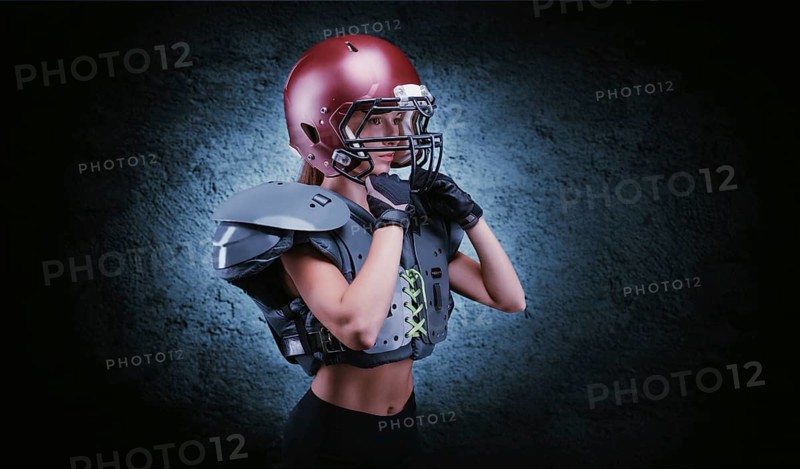 Brutal portrait of a girl in the uniform of an American football team player. Equipment advertising. Sports concept. Shoulder pads.