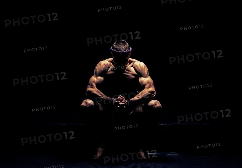 World champion in Thai boxing is sitting in the ring and getting ready for the next fight. The concept of sport