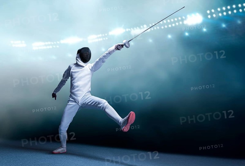 The fencer moves forward with a sword in his hand. Sport concept.