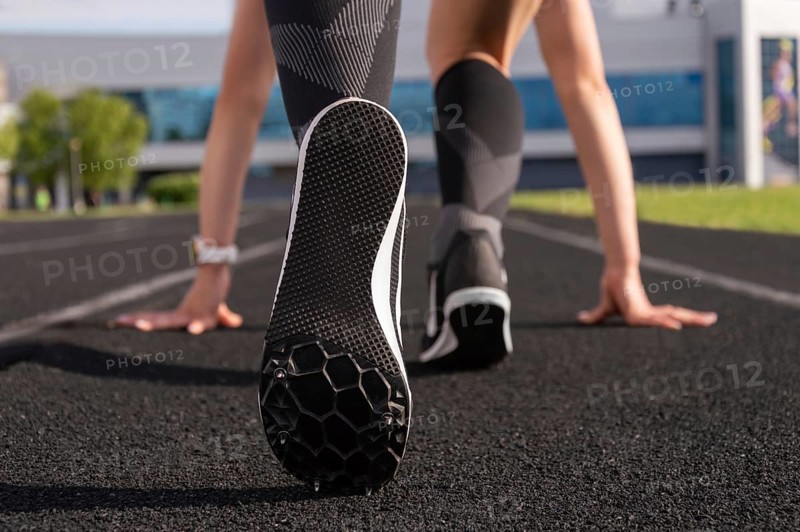 Professional runner stands on the track and prepares for the start of the race. Sports concept.