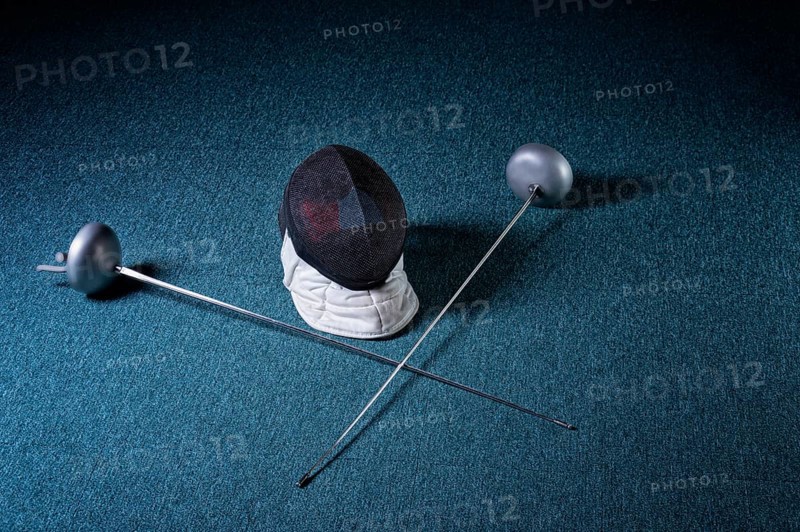 Two swords and mask lie on a blue background. The concept of fencing.