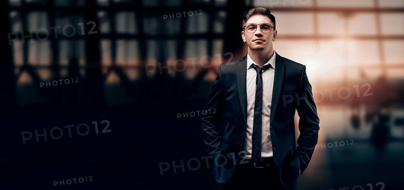 Portrait of a man in a business suit. He is standing at the airport and looking at the camera. Airline concept. VIP transportation. Private airlines. Charter flights.