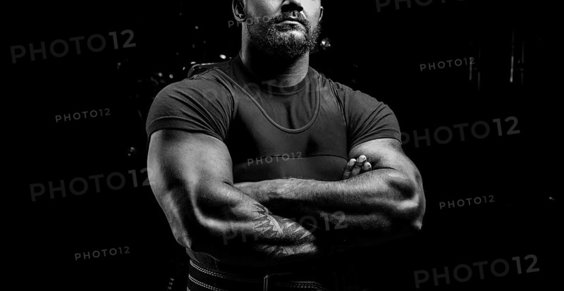Huge powerlifter stands in front of the camera and strains his huge hands.