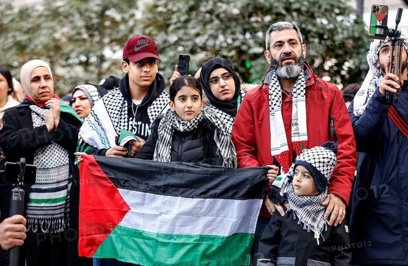 A family shows a Palestinian flag during the demonstration Freedom for the people of Gaza