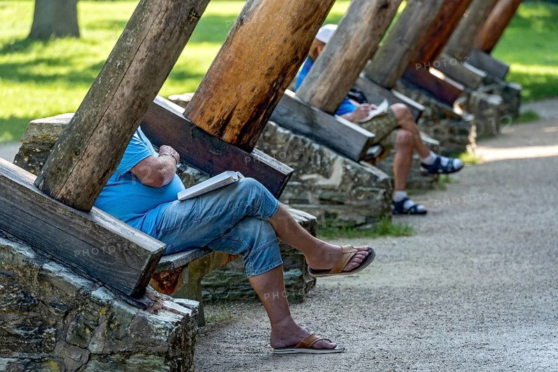 Men relaxing on benches between supporting beams of Gradierbau I