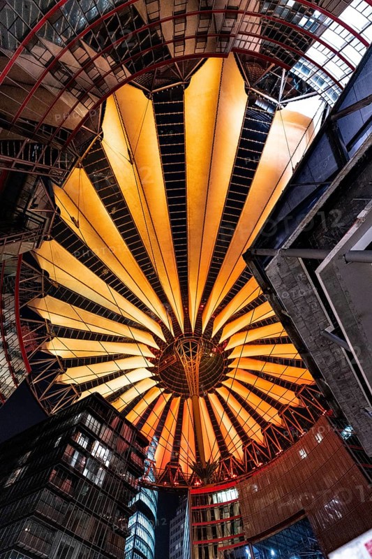 Modern roof construction with warm orange lighting in the city